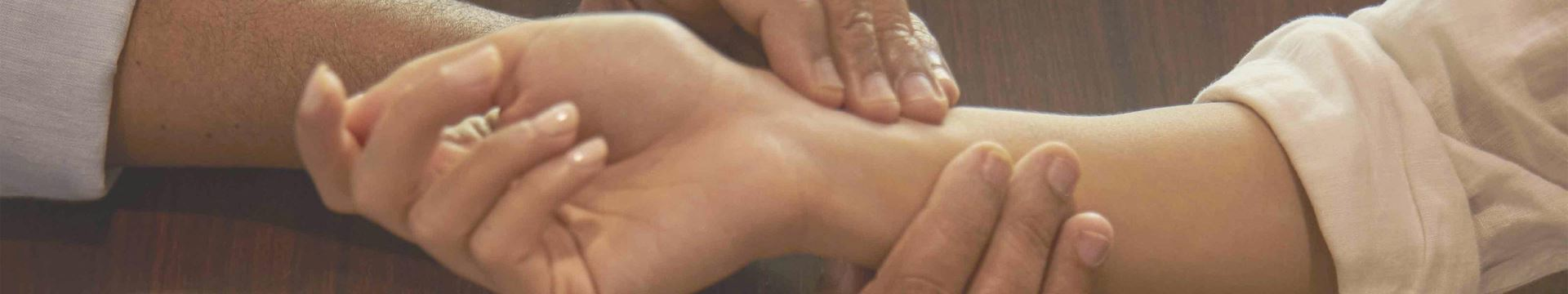 doctor checking pulse on hand